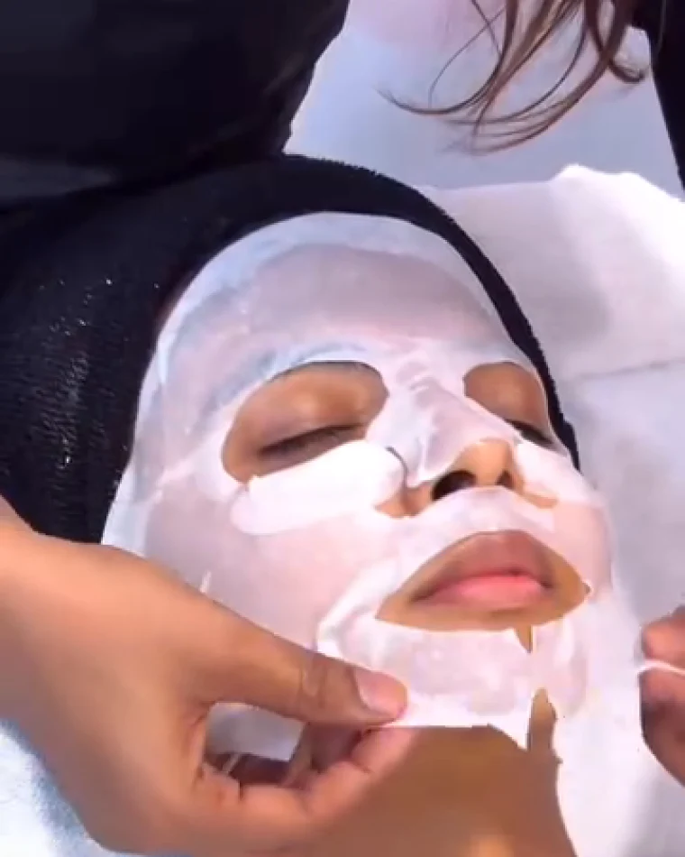A hydrating sheet mask smoothed down over the whole face.