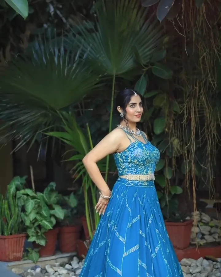 A teal embroidered outfit against palms and banana leaves, from our styled shoot.