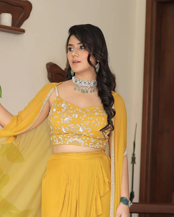 A mustard-yellow crop top and draped skirt with a sheer cape, an emerald choker, from our styled shoot.