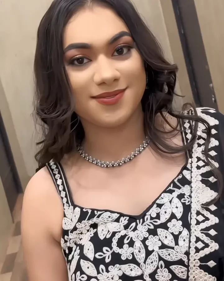 Cocktail look: a black and white embroidered lehenga with a diamond necklace, in a corridor.