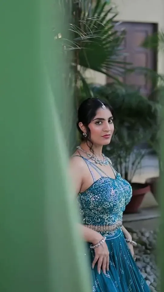 Mehendi look from our styled shoot: a fishtail braid and a green outfit, framed by heritage arches.