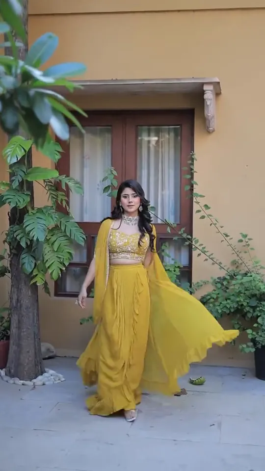 Haldi look from our styled shoot: a yellow ruffled skirt swept out mid-turn in a paved courtyard.