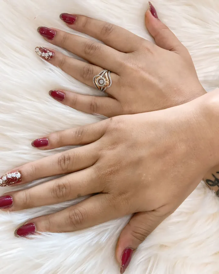 Two hands crossed over each other on a white fur throw, shot from directly above.