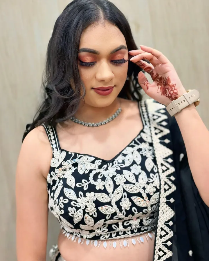 Three-image carousel of one client in a black lehenga with white thread-and-mirror embroidery and a sheer black dupatta.