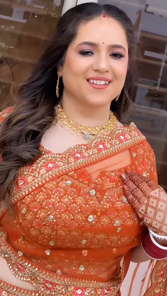 Karwa Chauth look from our styled shoot: an orange embroidered lehenga with red and white bangles.