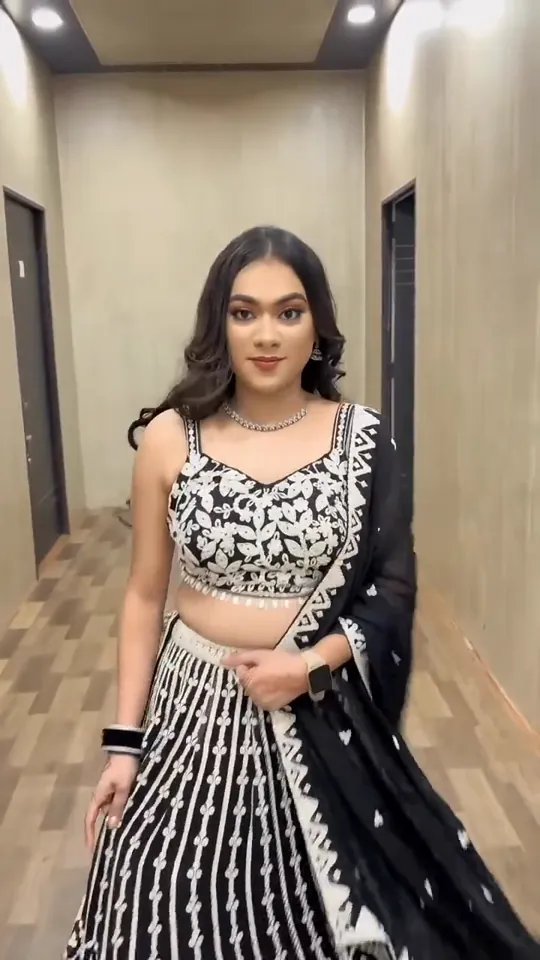 Cocktail look from the styled shoot: a black and white embroidered lehenga with a diamond necklace, in a corridor.
